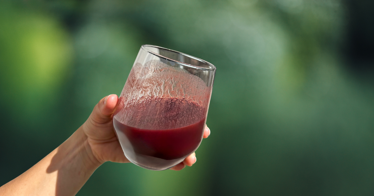 NUI NONI Saft im Glas grüner Hintergrund